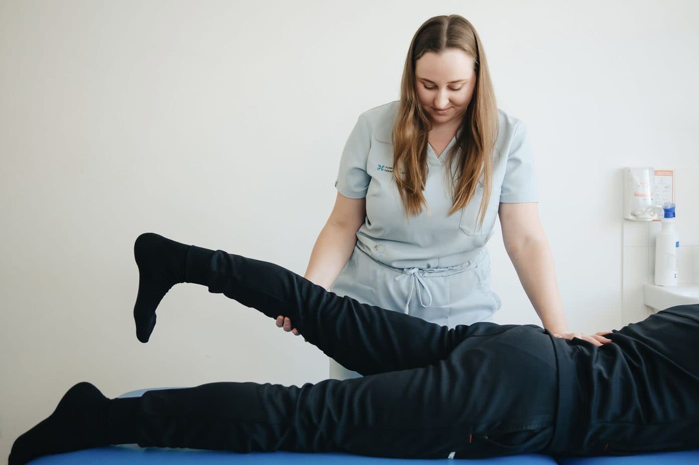A physical therapist working with a patient in a clinic